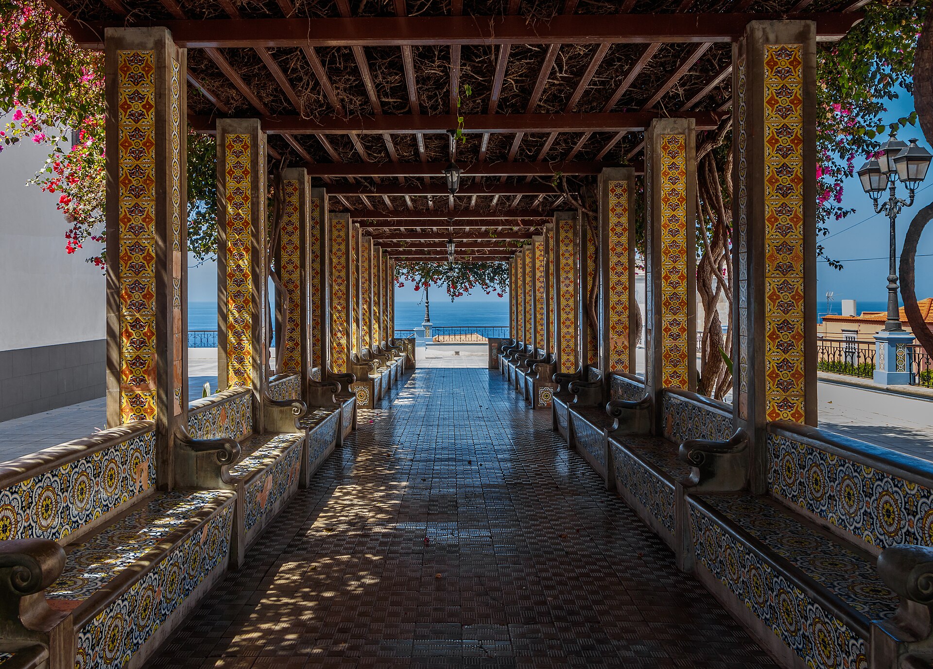 Una columnata andaluza con azulejos que da al mar